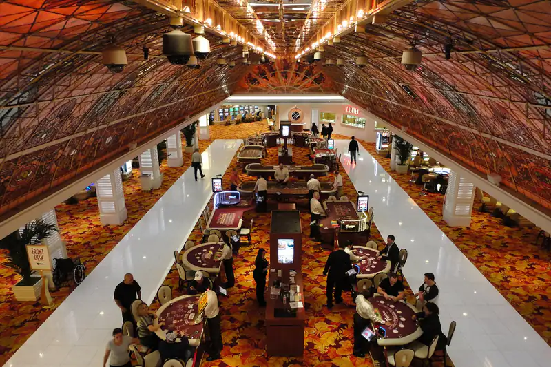 A high view of a casino floor with rows of table games